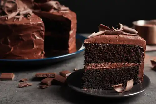 Plate with slice of tasty homemade chocolate cake on table